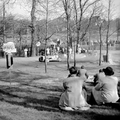 Eläintarhan ajot äitienpäivänä 1951. Autojen kilpa-ajot, yleisöä radan varrella katselemassa autojen kilpa-ajoa.