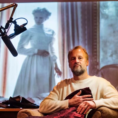 Heikki Kossi studiollaan, taustalla Nicole Kidman valkokankaalla elokuvassa Lumotut.