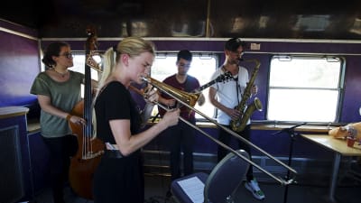 Jazzmusiker spelar i ett tåg.