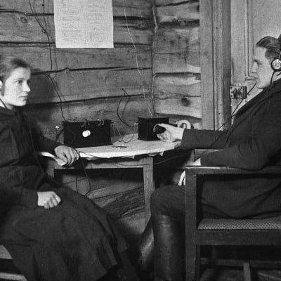 Myymäläapulainen Hanna Kauhanen (myöhemmin Hanna Leväsalmi)  ja kauppias Oskari Kauhanen kuuntelevat hänen vuonna 1926 ostamaa radiota  Kiuruvedellä, Rajakkojoen kylässä.