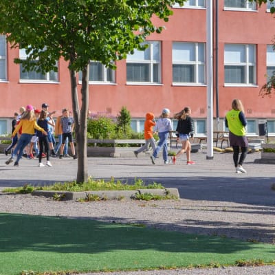 Skolelever springer ute på skolgården