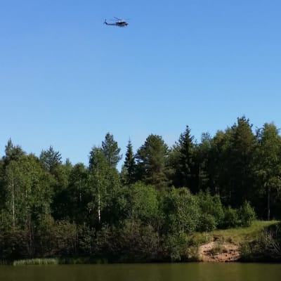 En helikopter flyger över olycksplatsen