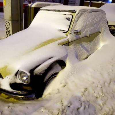 Lumisia autoja jääneet lumivallin taakse aurauksen jäljiltä.