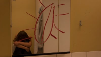 Klotter på en spegel och en olycklig ungdom.