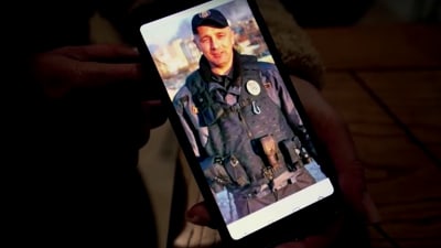 En telefon med en bild av en man i militär utrustning.