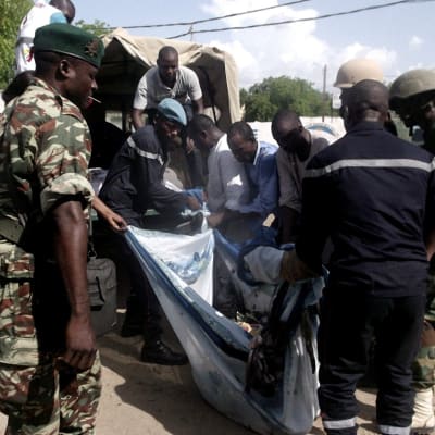 Säkerhetsstyrkor bär bort en av kropparna efter ett av bombdåden i Maroua i Kamerun den 22 juli 2015.