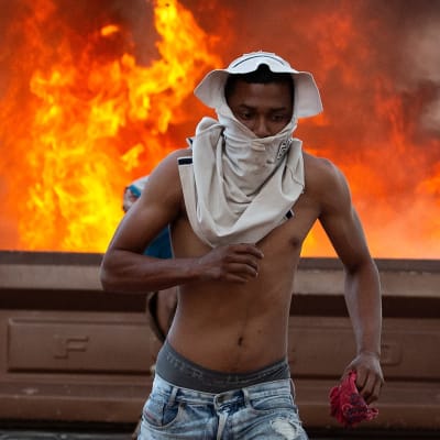 Ung man springer undan sammandrabbningarna i staden Pacaraima vid gränsen mellan Venezuela och Brasilien