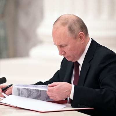 Presidentti Vladimir putin selaa papereita Venäjän turvallisuusneuvoston istunnossa.