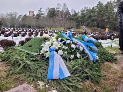 En begravningskrans ligger på begravningsplatsen, vid fänrik Gösta Karlssons grav. Bilden tagen 12.1.2023. 