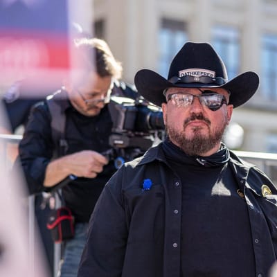 Stewart Rhodes, med cowboyhatt på huvudet och en lapp för vänster öga, ser rakt in i kameran.