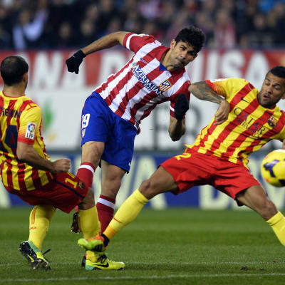 Atletico Madridin Diego Costa taistelee pallosta Barcelonan Javier Mascheranon ja Dani Alvesin kanssa.