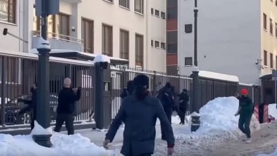 Maskerade människor med släggor utanför Finlands ambassad i Moskva i vinterväder.