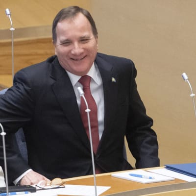 Stefan Löfven fotograferad när han nyss blivit vald till statsminister för sin andra mandatperiod den 18 januari 2019. Löfven är omringad av andra svenska politiker i den svenska riksdagen.