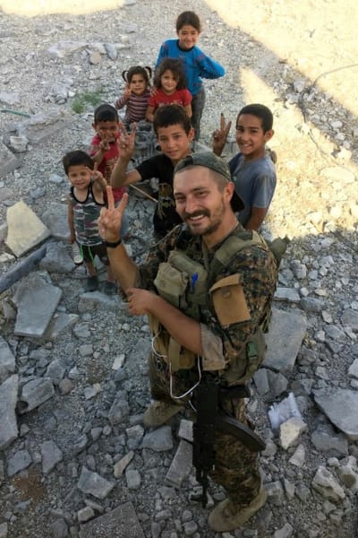 Den finska frivilligsoldaten "Bagok Kullervo" med en grupp barn utanför Raqqa.