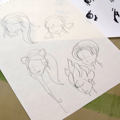 Ett papper med blyertsskisser av seriefigurers huvuden. Tecknat i mangastil.