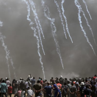 Palestiinalaismielenosoittajat juoksevat karkuun Israelin ampuessa kyynelkaasua Gazan ja Israelin rajalla.