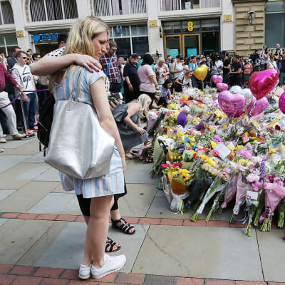 Ihmiset toivat kukkia terrori-iskussa kuolleiden muistolle Manchesterissa 25. toukokuuta.