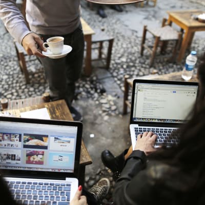 Ihmisiä kannettavien tietokoneiden kanssa kahvilassa Istanbulissa.