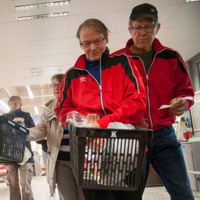 Kauppias Veli-Matti Kokko jakaa pantillisia ostoskoreja asiakkaille