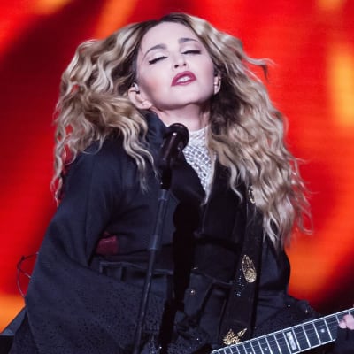 Madonna blundar och spelar elgitarr.
