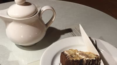 Te, kaka och kniv på bord