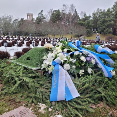 Hautakumpu, kukkalaiteitta sinivalkoisin nauhoin.