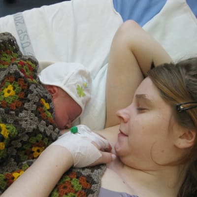 En kvinna med ett spädbarn i sin famn.