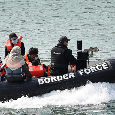 Rajavartiosto kuljettaa pelastusveneellä siirtolaisia Englannin kanaalissa. 