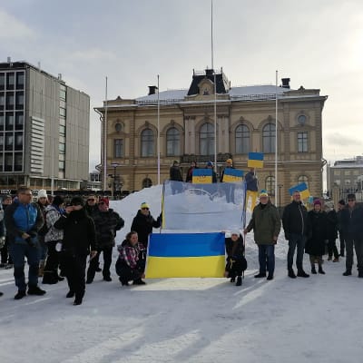 Mielenosoittajia Hämeenlinnan torilla Ukrainan liput käsissä.