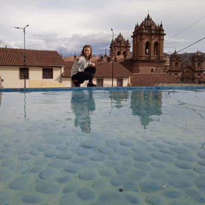 Jacintha Damström sitter på huk vid en damm i Cusco.