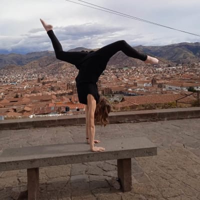 Cirkusartisten Jacintha Damström står på händer med en vy över den peruanska staden Cusco i bakgrunden.