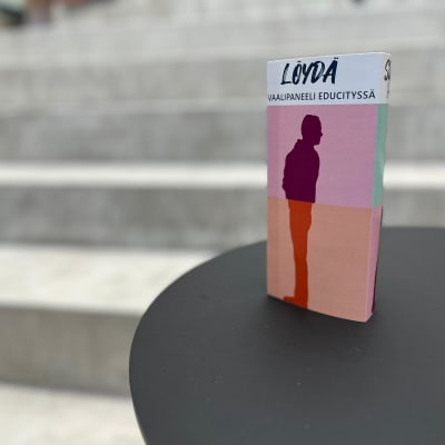 Vaalimainos pystyasennossa pienen pöydän päällä. Mainoksessa on teksti Löydä vaalipaneeli Educityssä.