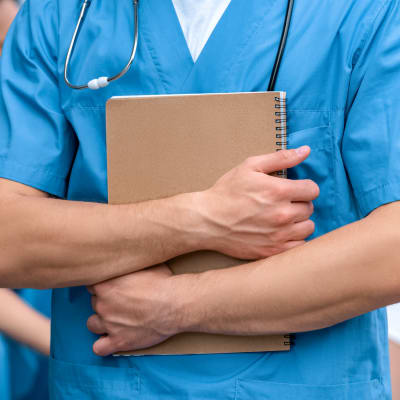 En läkarstudent håller i ett häfte. 