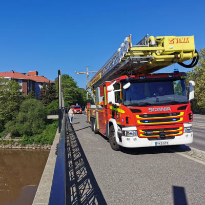 En brandbil och några andra bilar från räddningsverket står på Tomasbron i Åbo en sommardag.