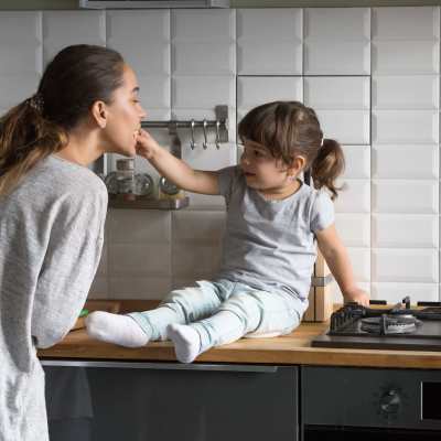 en mamma och hennes dotter i ett kök.