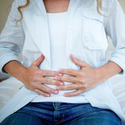 Gravid kvinna håller sig för magen