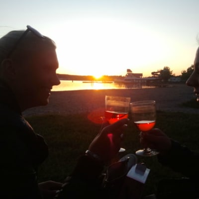 Två kvinnor dricker vin på stranden