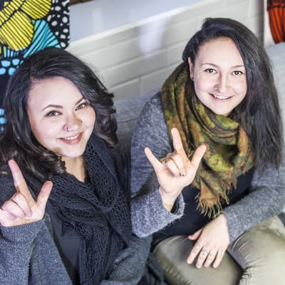 Viittomakieleksi musiikkikappaleita muuttavat Nina Kukkaslahti ja Alisa Nissinen näyttävät rakkauden merkkiä