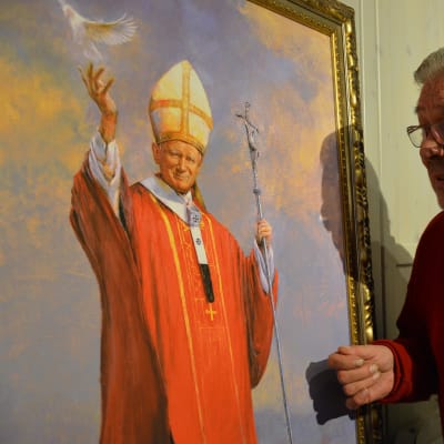 Muotokuvamaalari Fritz Jakobsson paavin muotokuvan äärellä.