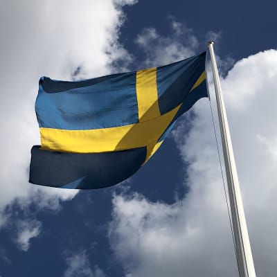 ruotsin lippu liehuu, valkoisia pilviä ja sinistä taivasta