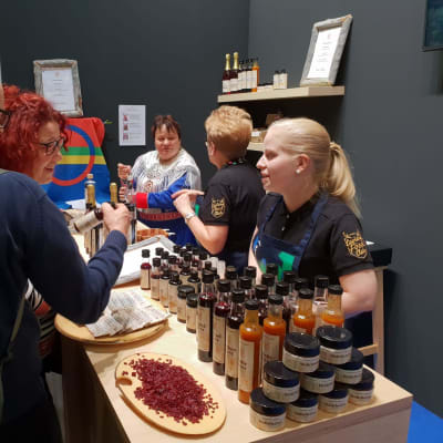 Teresa Jesche opastaa saksalaisia messuvieraita Lapin herkkujen saloihin.