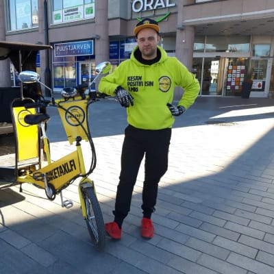 Biketaxin yrittäjä Miika Keihänen polkupyörätaksinsa vieressä Kuopion keskustassa.