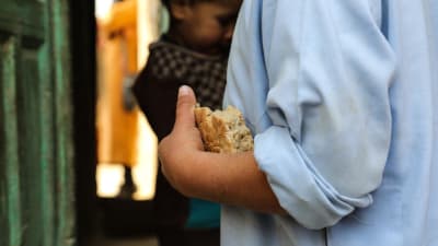 6-åriga aghanska pojken Sami håller ett bröd i handen.