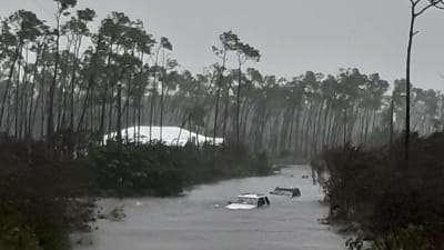 Bilar som flyter i vatten efter att vägen har översvämmat. 