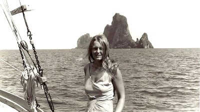 Svartvit bild av Ingrid på en båt med hav i bakgrunden.