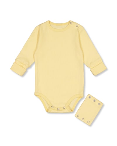 En gul body för spädbarn ur moderskapsförpackningen för 2023. 