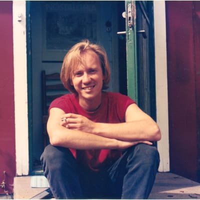 Musikern Micke Allén sitter på en trappa som ung och röker.