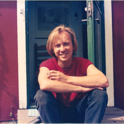 Musikern Micke Allén sitter på en trappa som ung och röker.