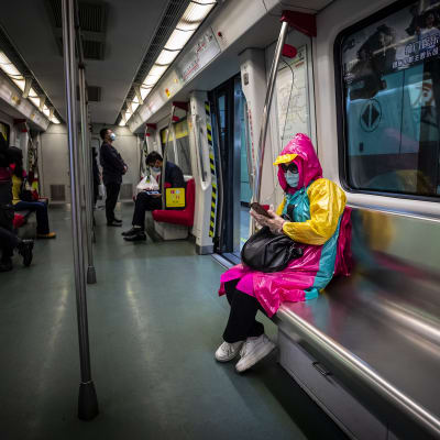 Nainen hengitysmaskin kanssa Guangzhoun metrossa Kiinassa.