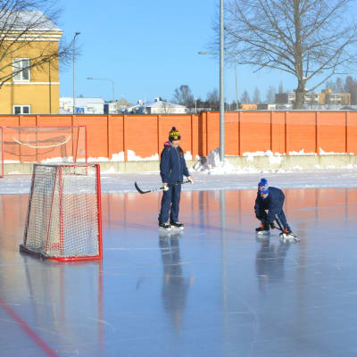 Två barn spelar ishockey